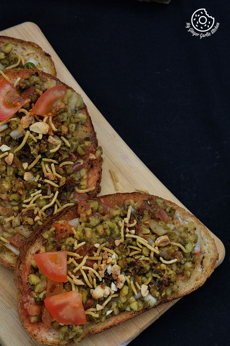 two pieces of moong dal toast with namkeen and different toppings on them