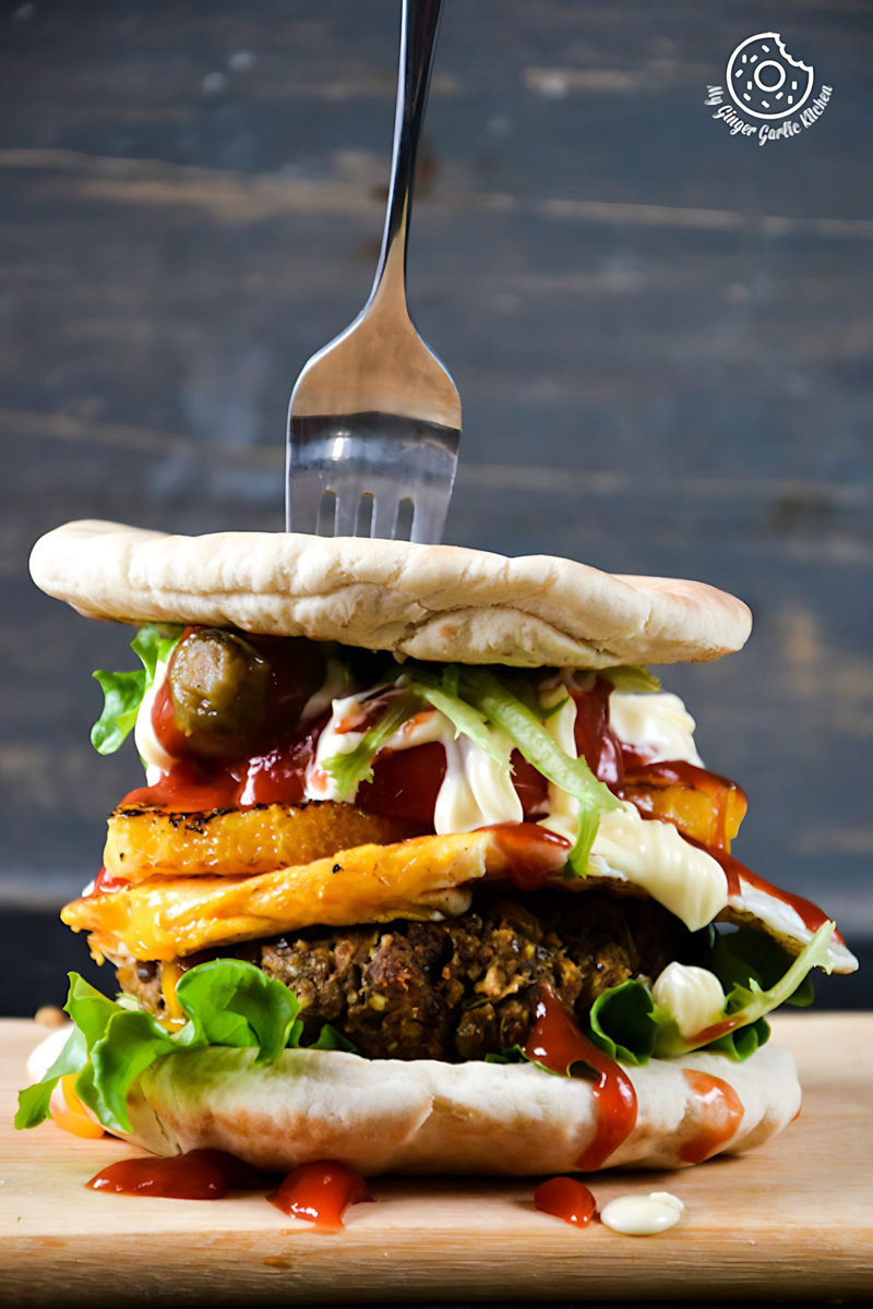 a mung bean pita burger with caramelised oranges and mango chutney with a fork sticking out of it