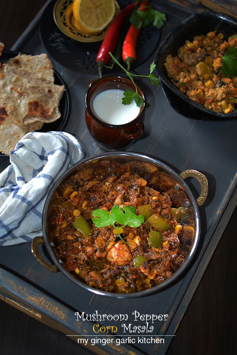 a bowl of mushroom pepper corn masala on a table with rotis, butter and a napkin