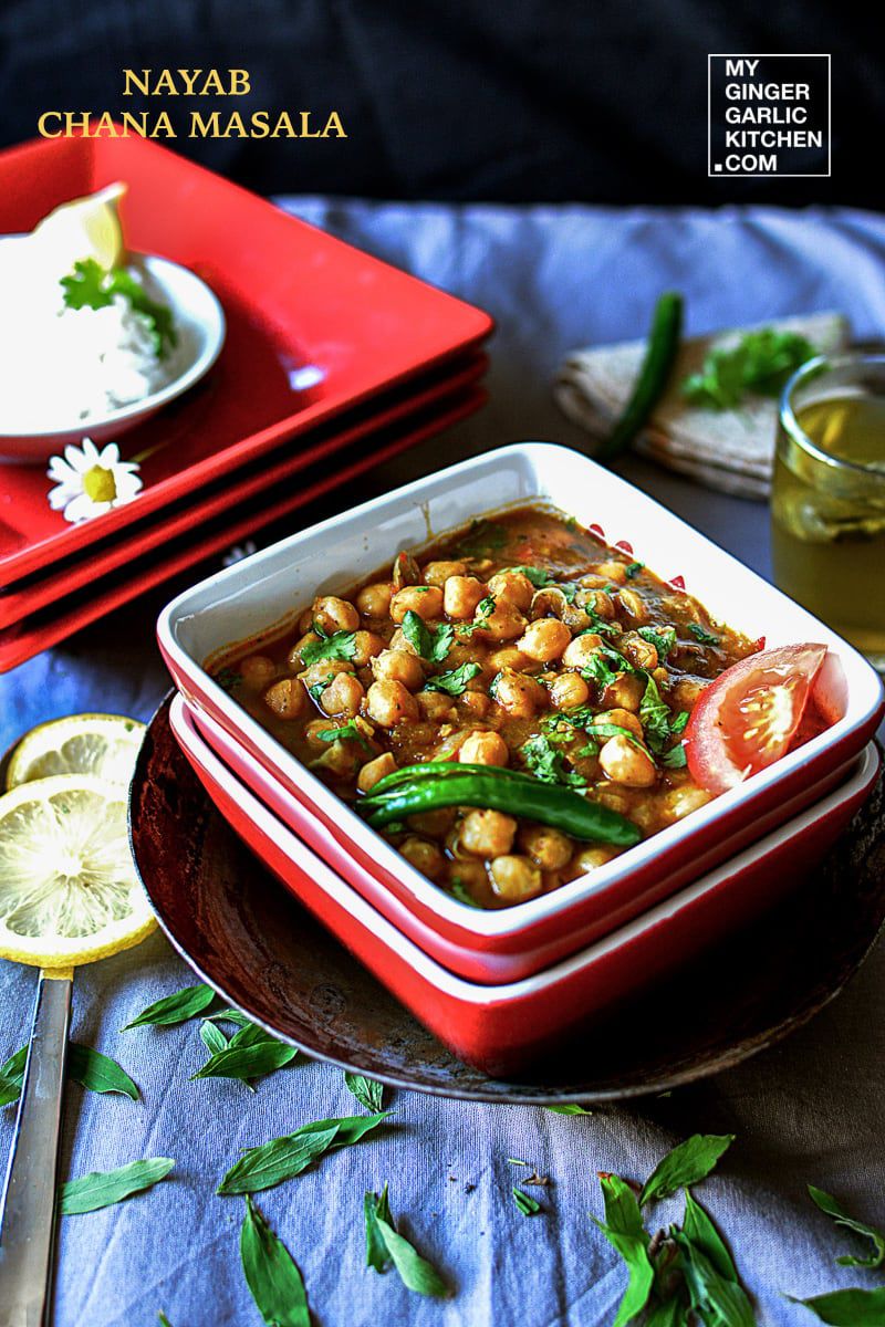a bowl of chana masala curry on a plate with a spoon