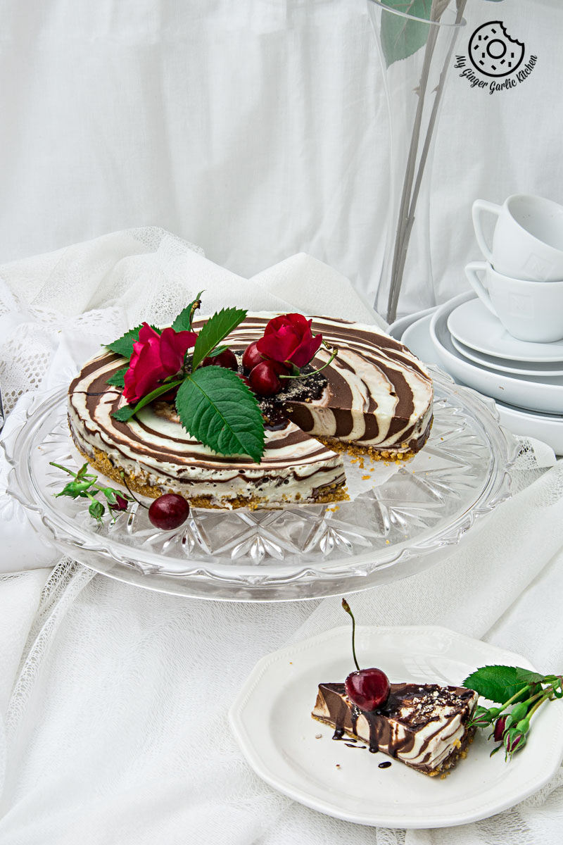 a no bake zebra cheesecake with chocolate and cherries on a plate