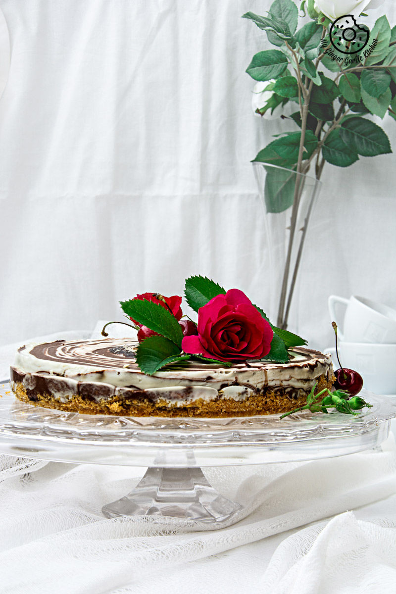 no bake zebra cheesecake on a cake stand with a rose on top of it
