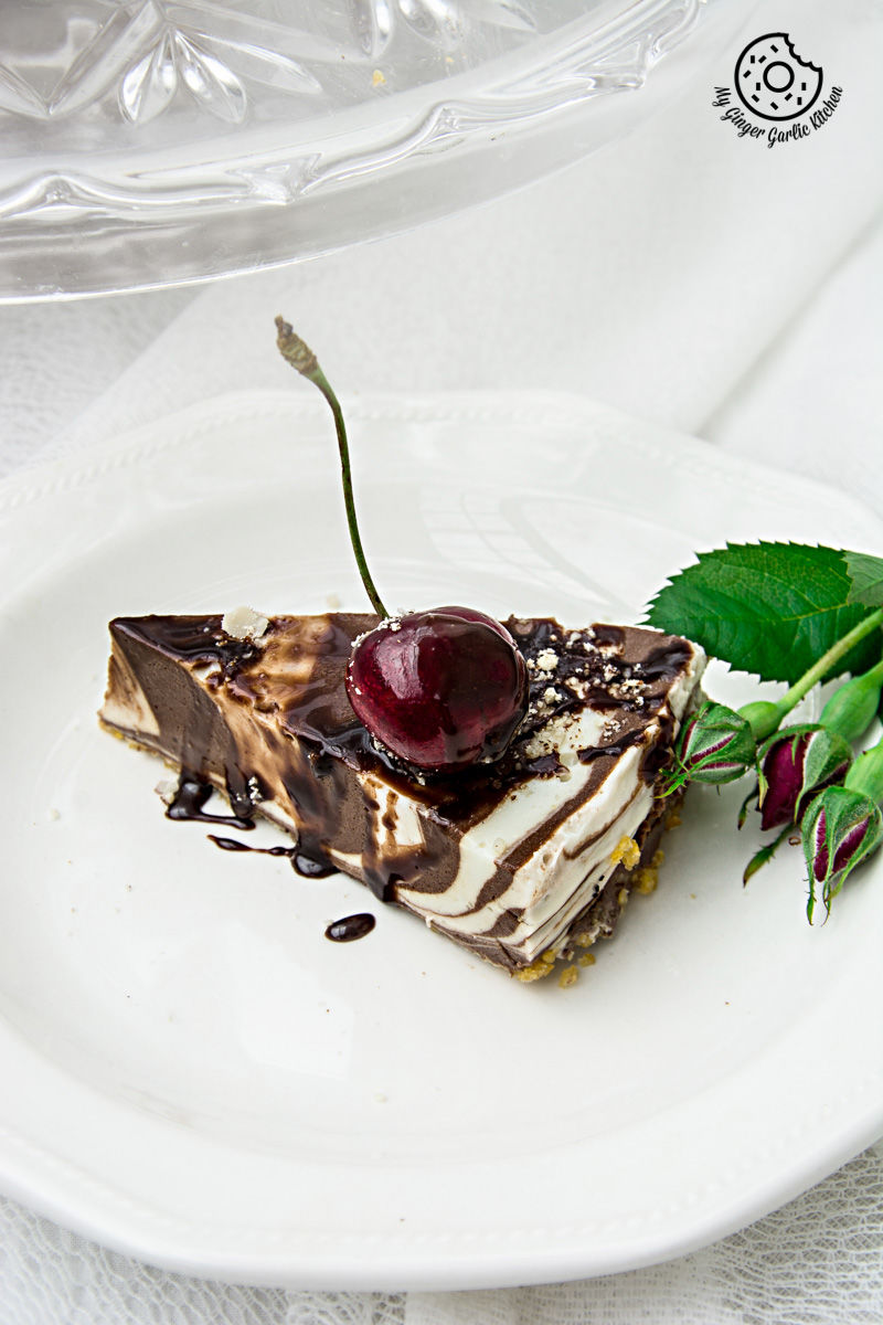 a piece of no bake zebra cheesecake on a plate with a cherry