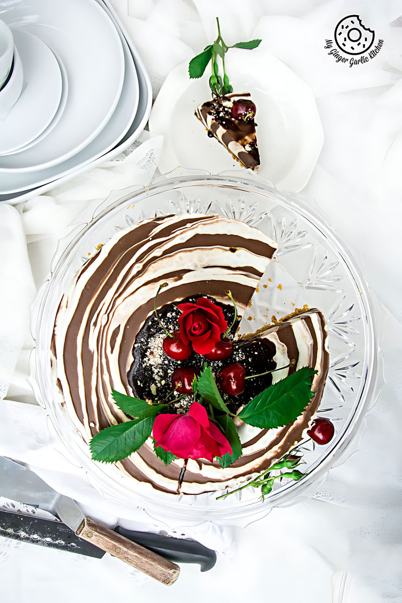 no bake zebra cheesecake with chocolate sauce, cherries and flowers on it