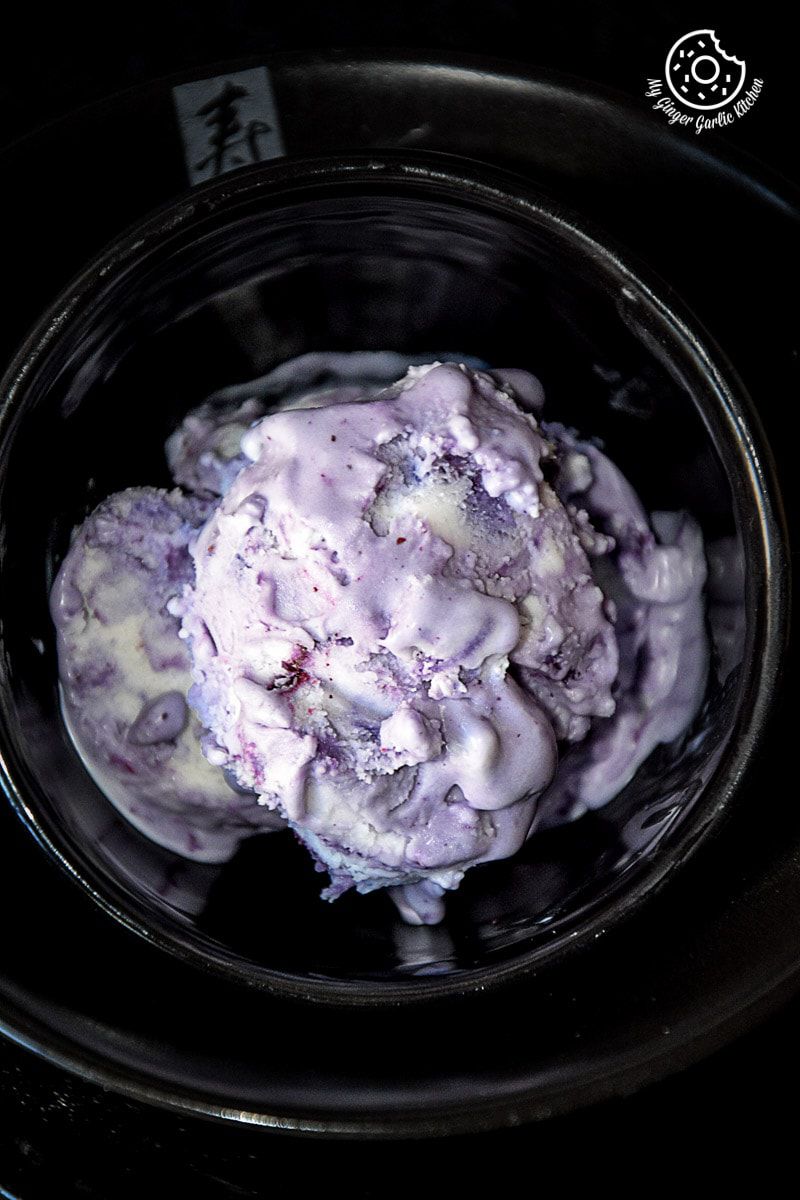 a bowl of vegan coconut blueberry ice cream in a black bowl