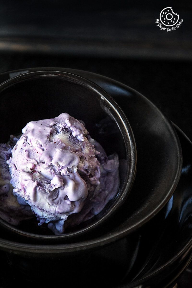 a bowl of vegan coconut blueberry ice cream in a black bowl