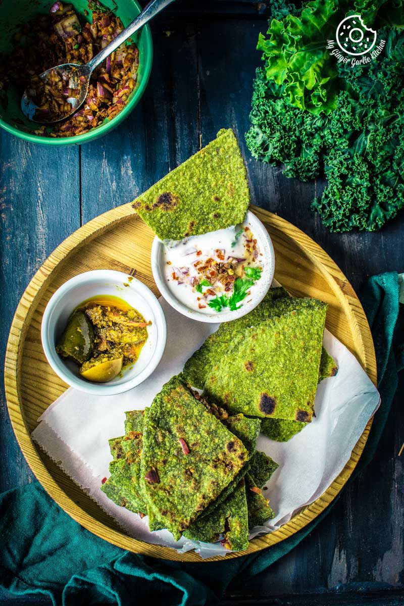 there is a plate of oats green parathas triangles with some kale and a green napkin