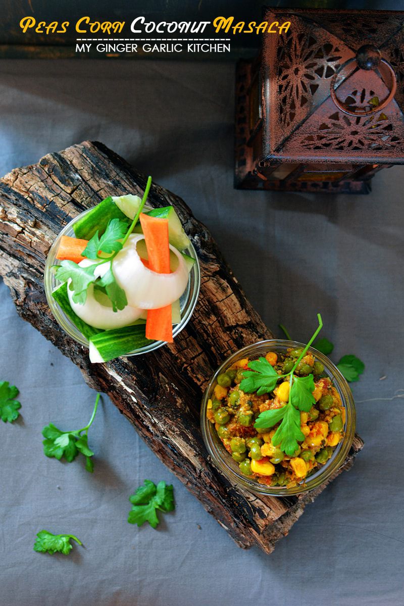 a bowl of peas corn coconut masala on a wooden board with a bowl of vegetables