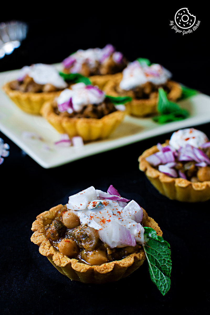 two small zero oil mint chola cornmeal tart with toppings on a table