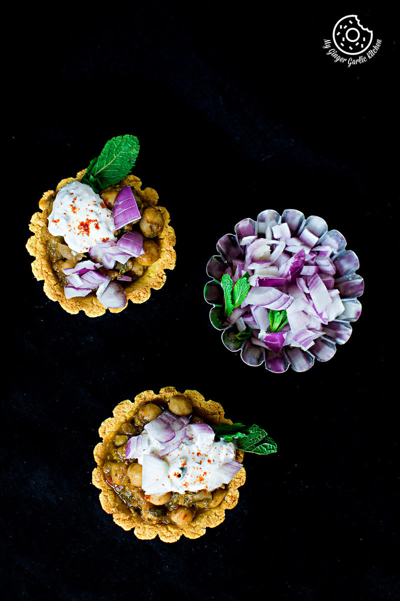 three small zero oil mint chola cornmeal tarts with red onions on a black surface
