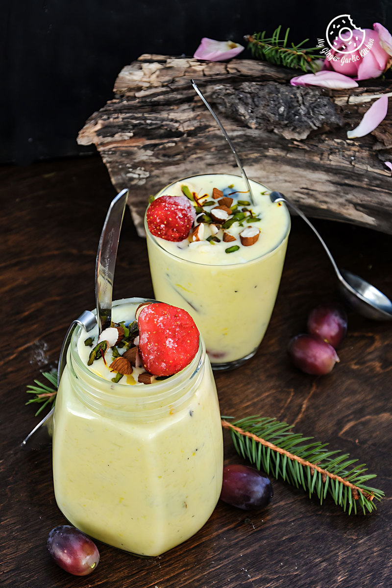 two glasses of oliya indian version of greek style rice pudding with fruit and nuts on a table
