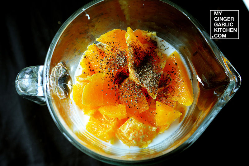 a blender with oranges and spices in it