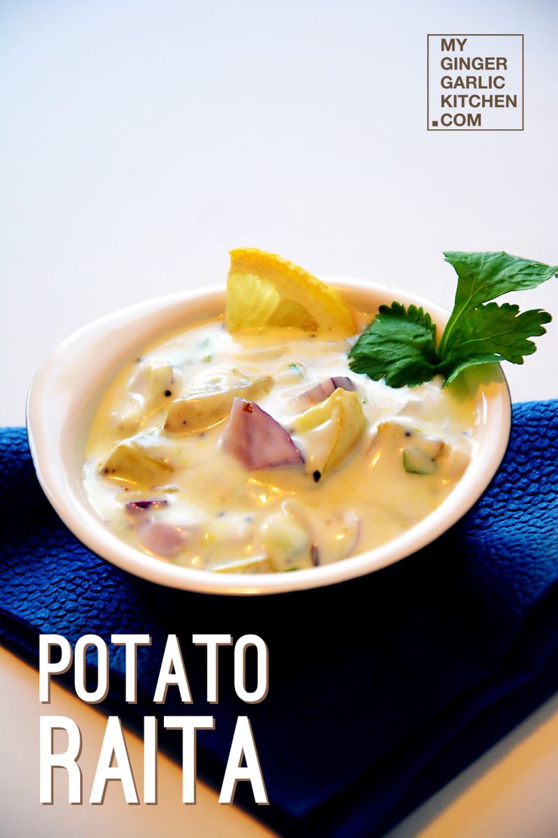 a bowl of potato raita with a lemon wedge on top