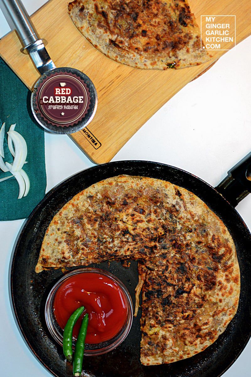 a red cabbage paratha is sitting on a pan with sauce