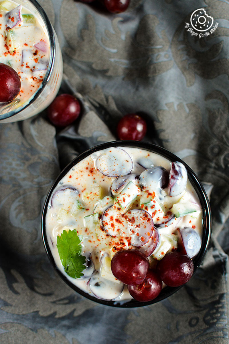 two cups of red grapes onion cucumber raita with grapes and garnish