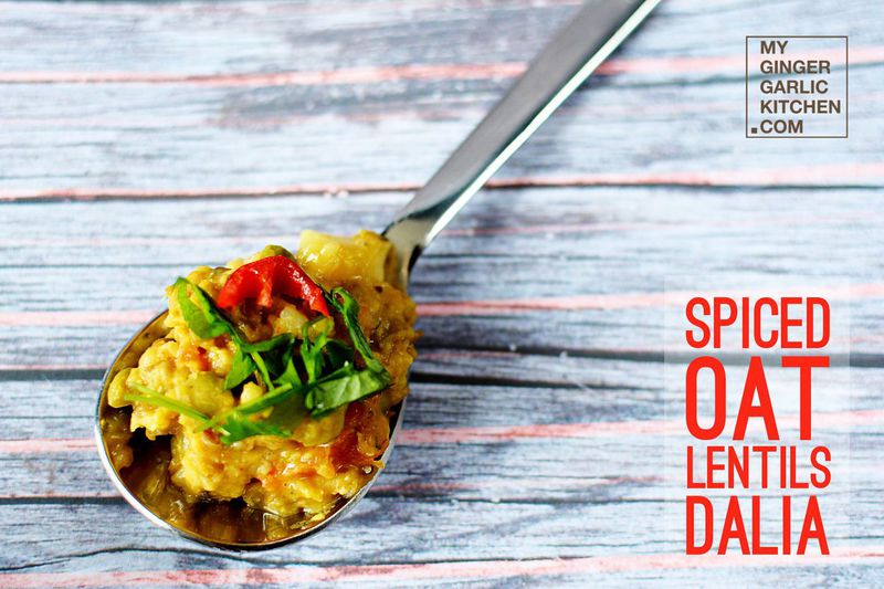 spoon with a spoon full of spiced oat lentils dalia on a wooden table