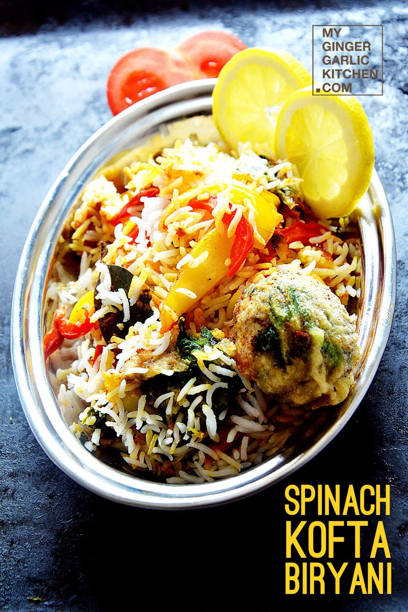 a bowl of food with rice and vegetablesa plate of spinach kofta biryani with lemon slices on it