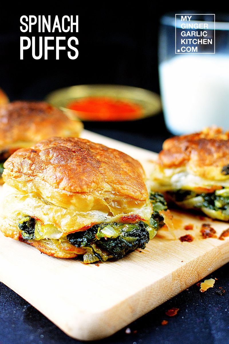 two spinach puffs on a cutting board with a glass of milk