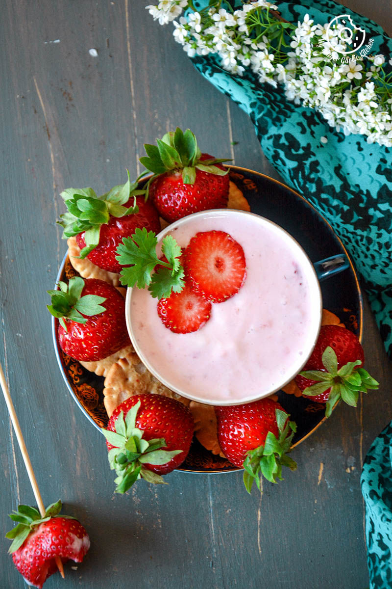 a bowl of strawberry cheesecake dip and a plate of strawberries