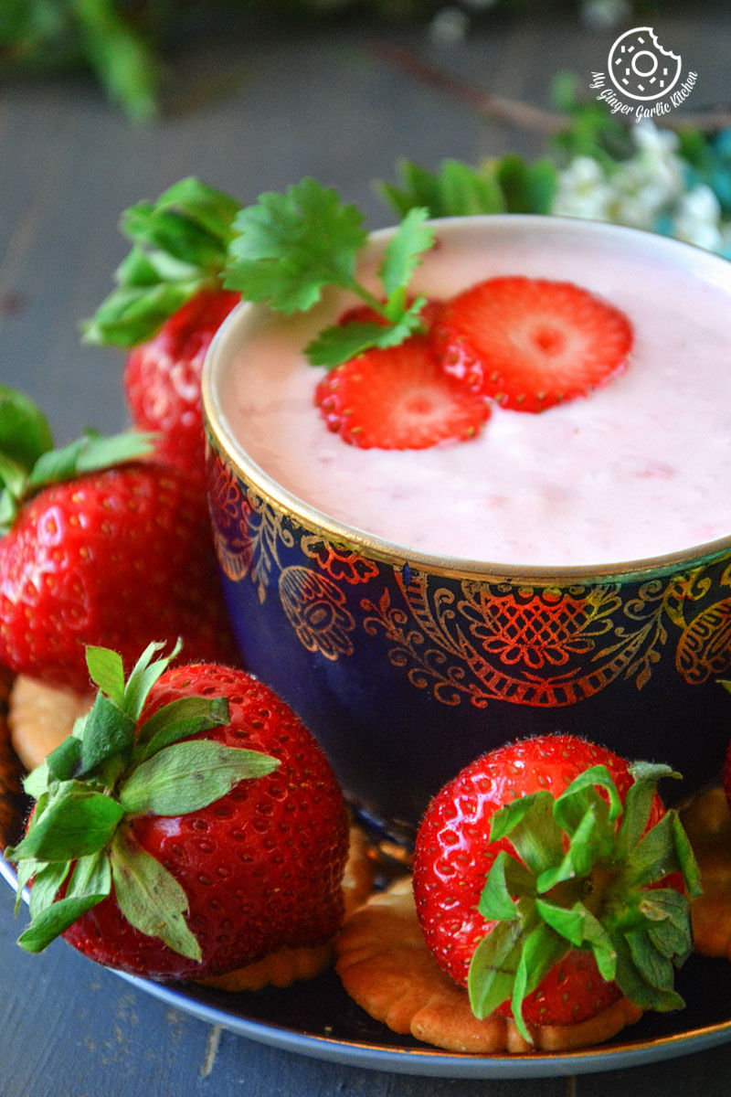 a bowl of strawberry cheesecake dip for fruits and snacks on a plate