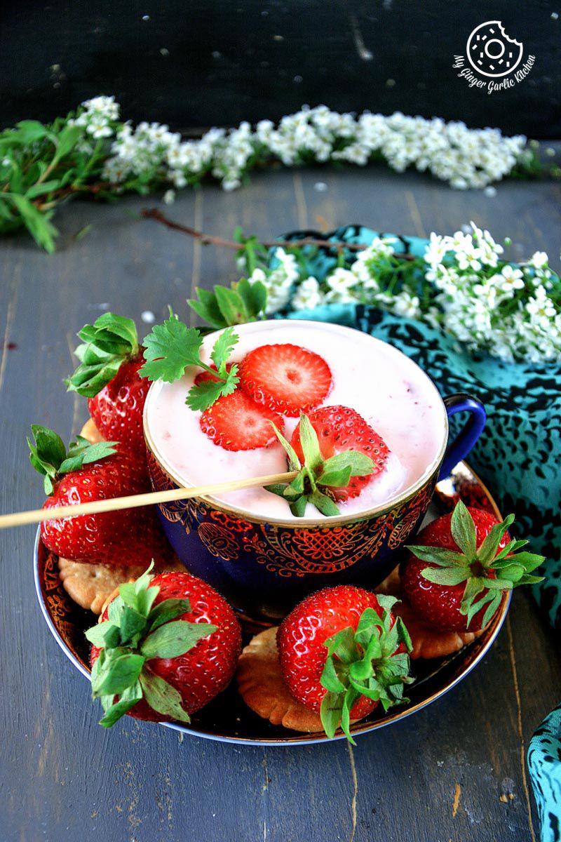 a bowl of strawberries and a bowl of strawberry cheesecake dip
