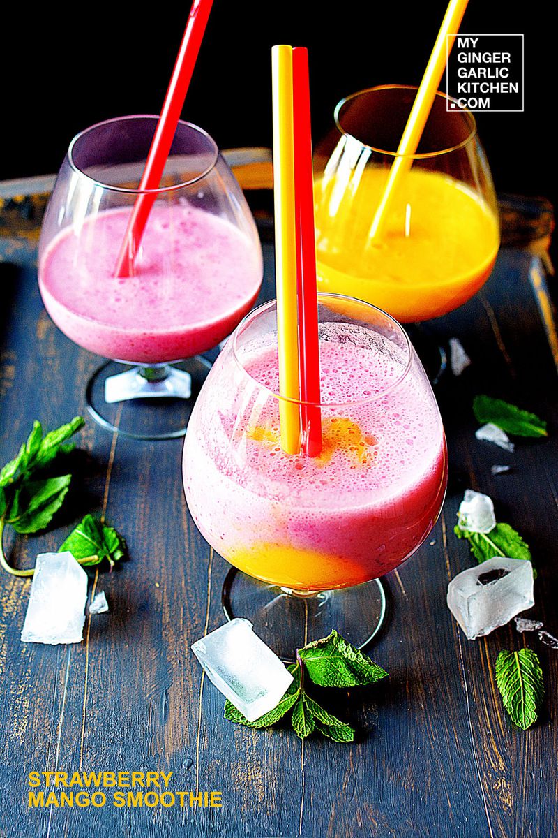 three glasses of strawberry mango smoothie with ice cubes and mint leaves
