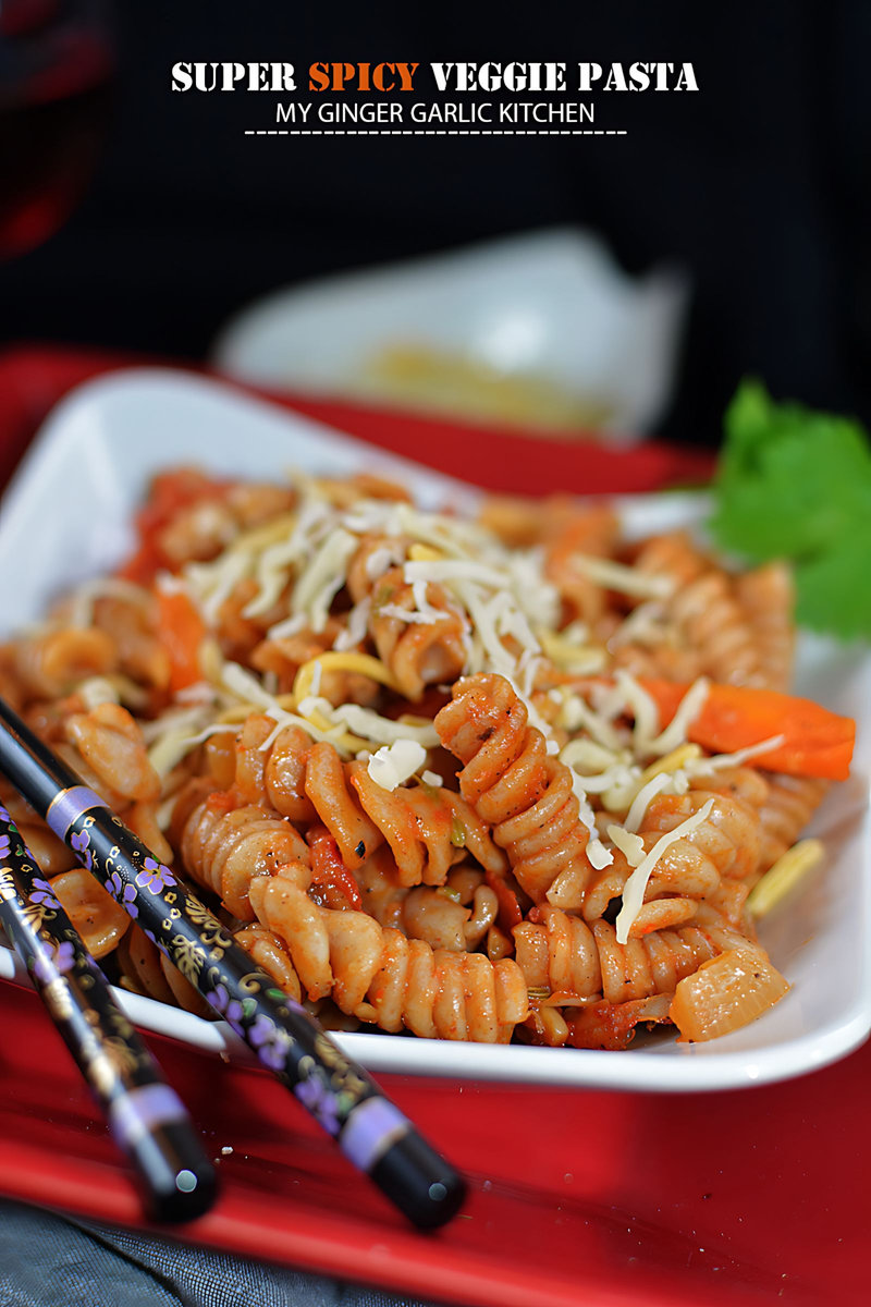 a plate of super spicy veggie pasta with carrots and cheese on it