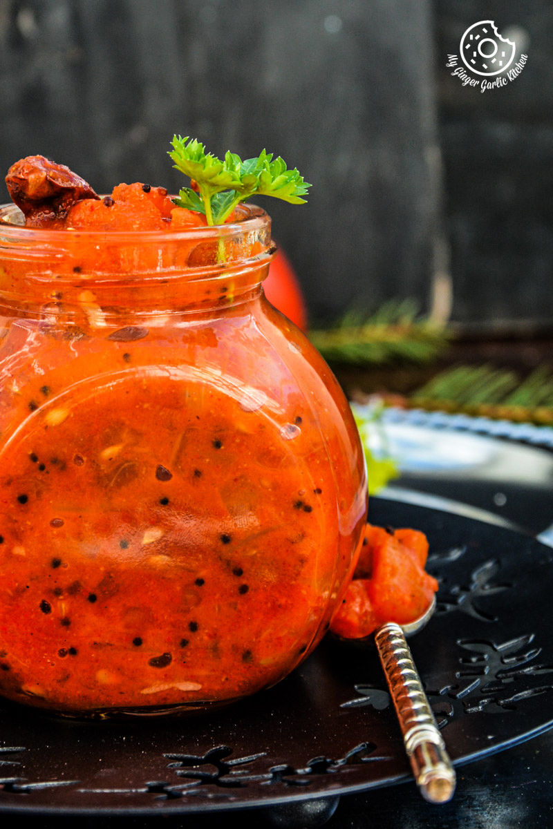 a jar of tomato mustard garlic chutney that is sitting on a plate
