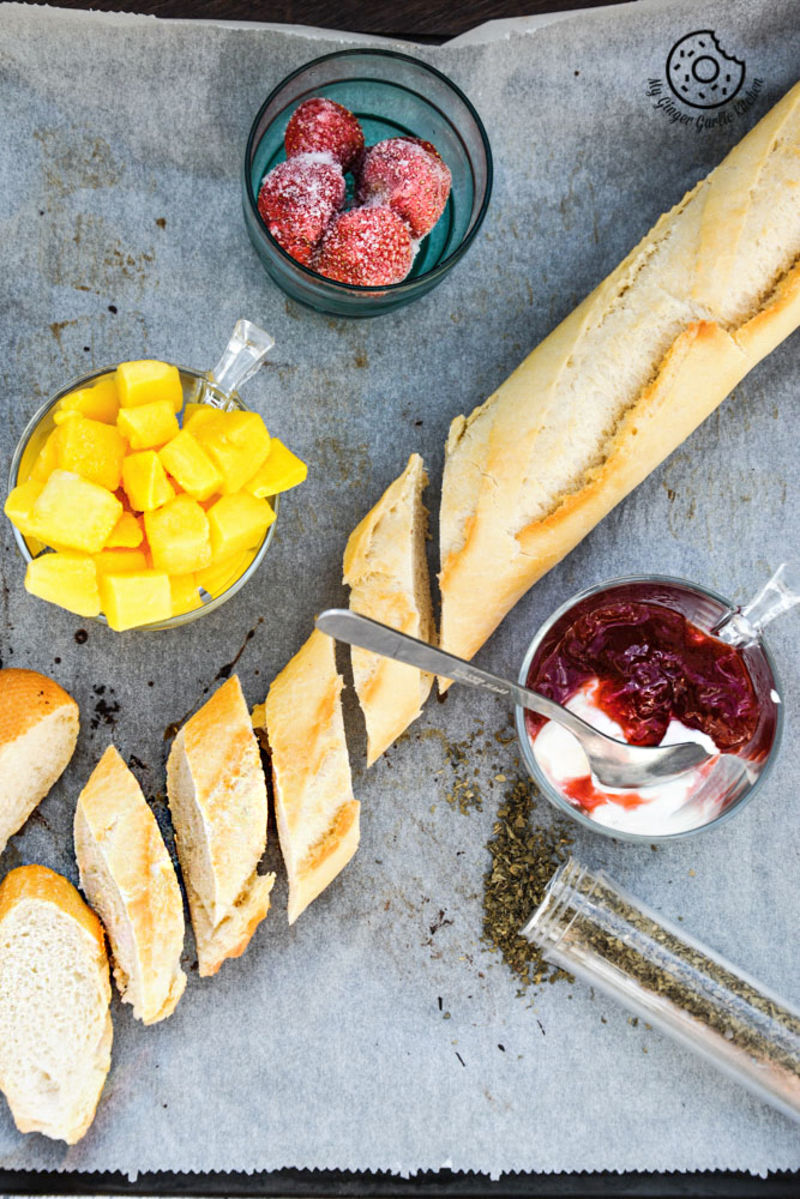 a tray with bread, fruit, and a knife on it