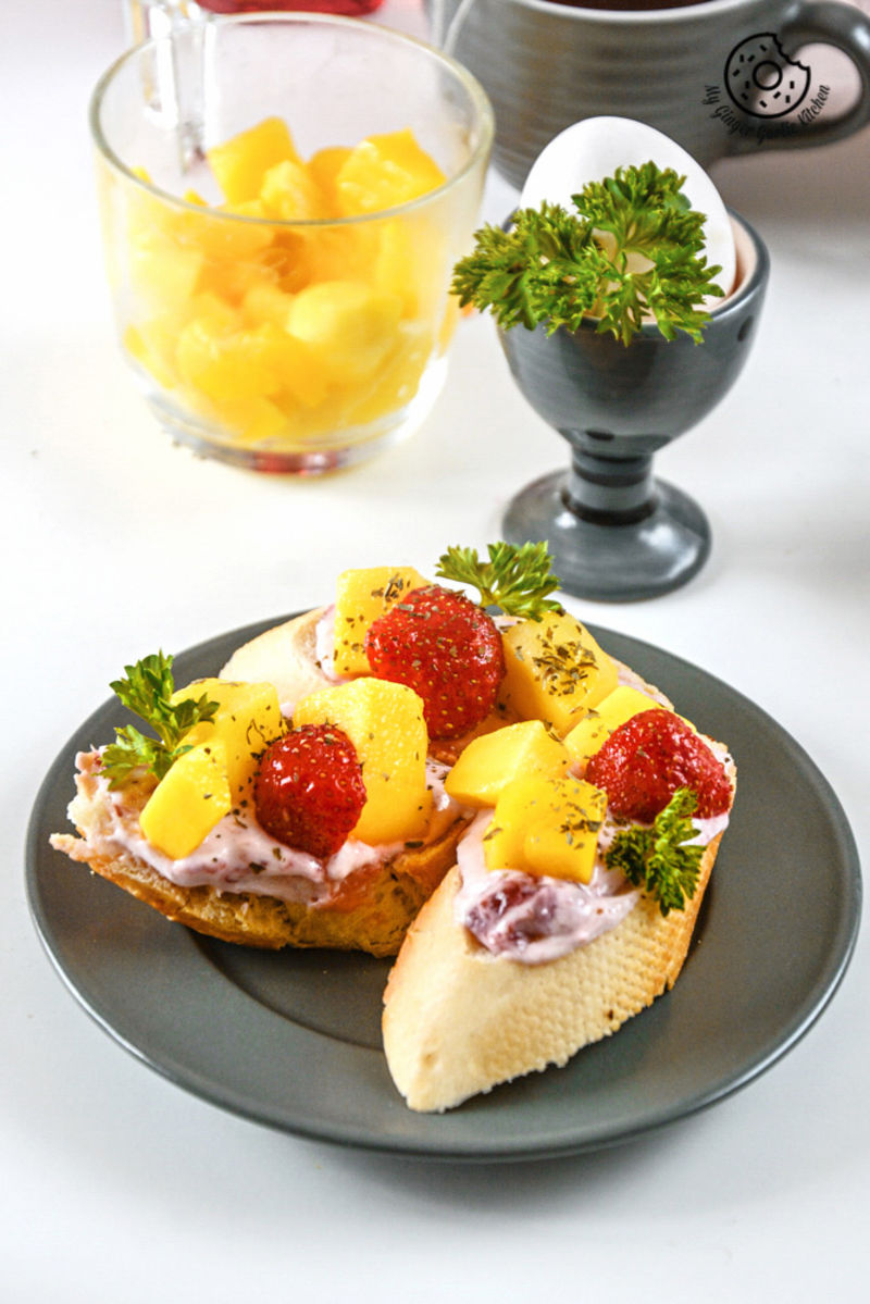 a plate with a tropical bruschetta with berry yogurt cheese and fruits on it