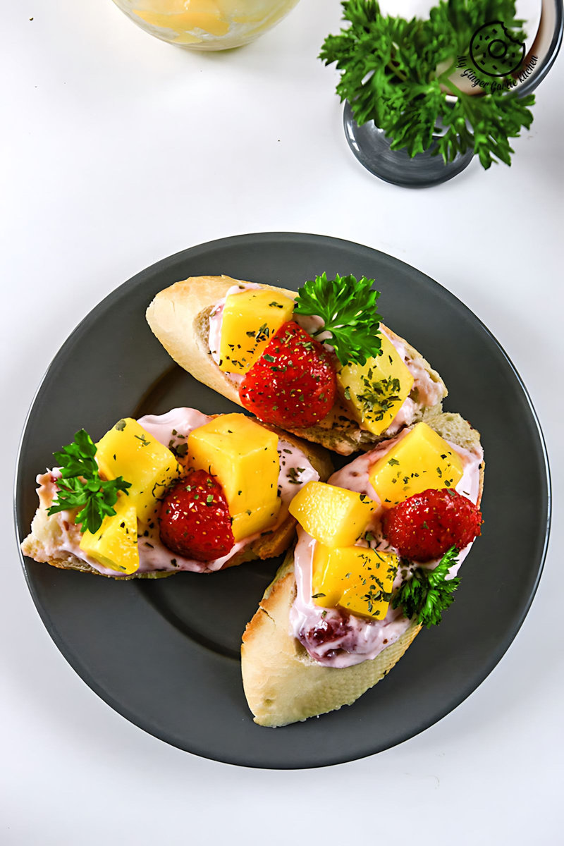 three pieces of tropical bruschetta with berry yogurt cheese with fruit on a plate