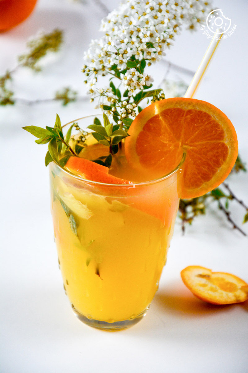 a glass of virgin ginger mimosa with a straw and a flower