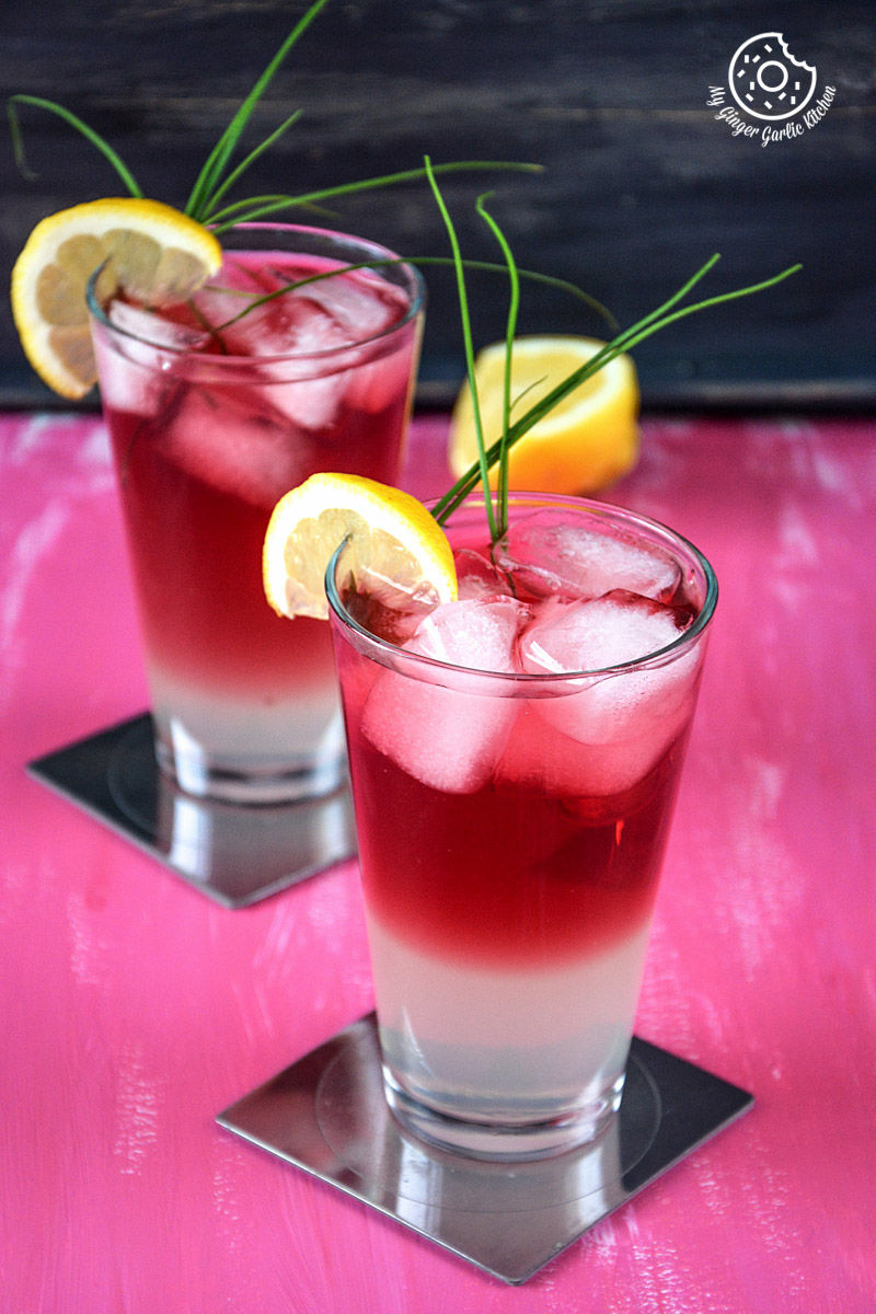 two glasses of red and white watermelon lemonade with lemon slices