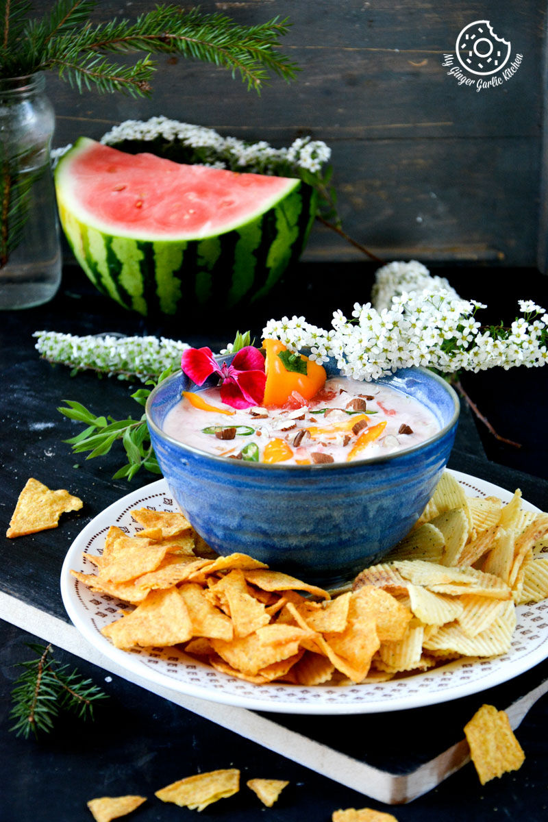 a bowl of watermelon onion dip and chips on a plate