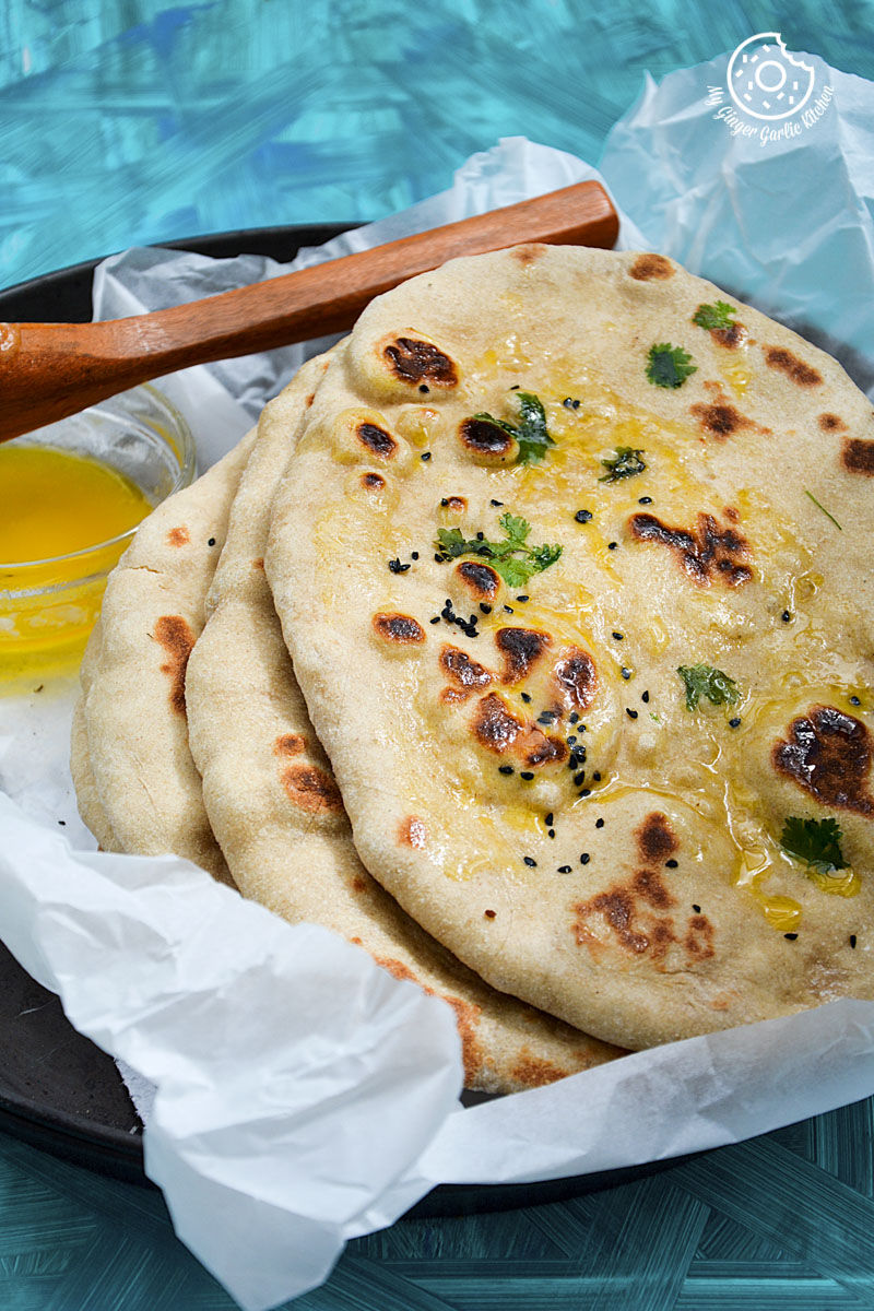 there are three yeast free whole wheat naans on a plate with a spoon and ghee