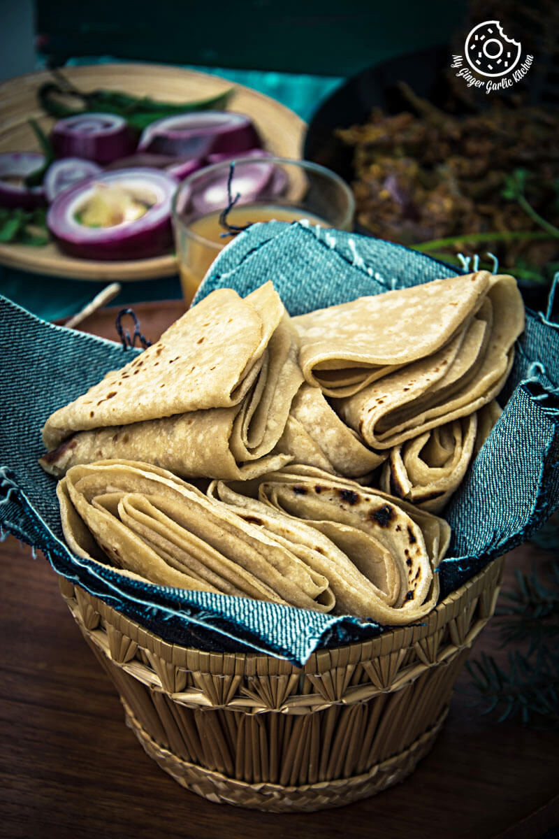 a basket of duppad roti aka pad wali roti on a table with other food