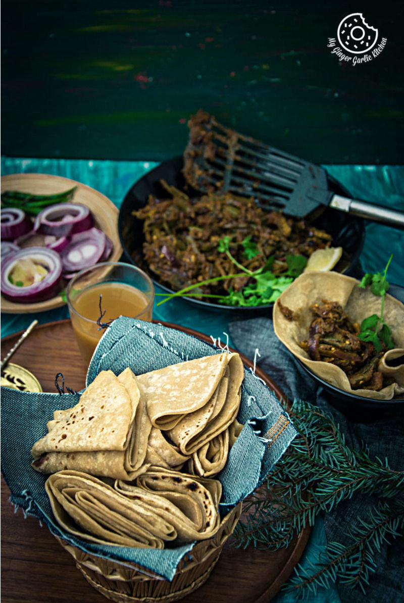 some achaari dahi bhindi with pad wali roti on a table with a bowl of salad