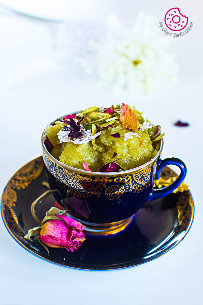 there is a cup of Aloo Halwa on a saucer with a flower