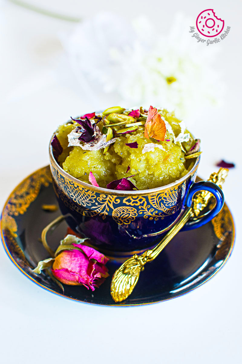 there is a bowl of Potato Halwa with a spoon and a flower
