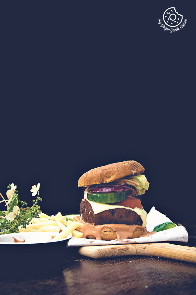 a aloo tikki burger and french fries on a table