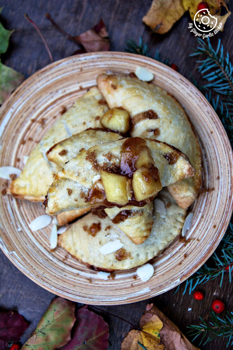 apple hand pies is on a table with almond flakes