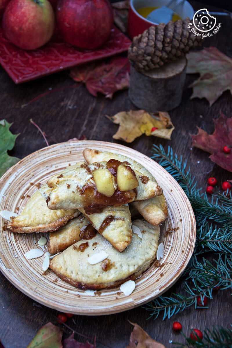 a plate of apple hand pies with almond flakes on the table