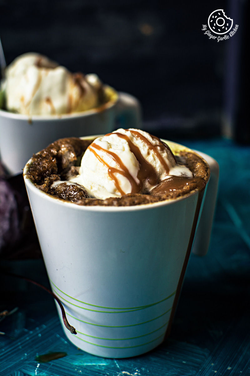 two cups of eggless apple pie mug cake with ice cream and caramel