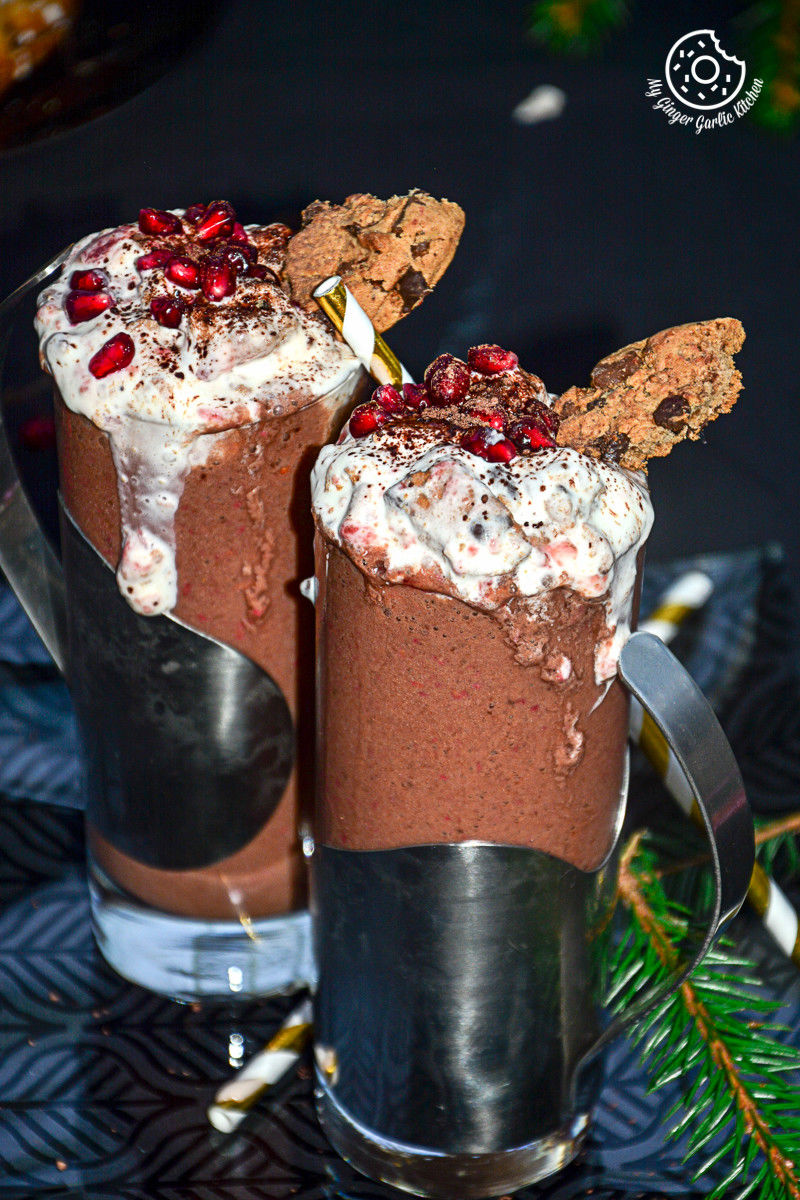 two glasses ofbanana berry choco coffee smoothie with whipped cream and chocolate cookies