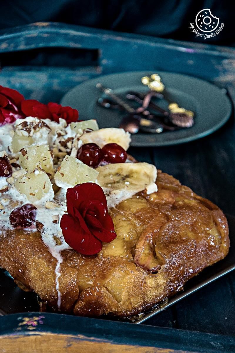 a banana pineapple upside down cake with toppings and flowers on it on a plate