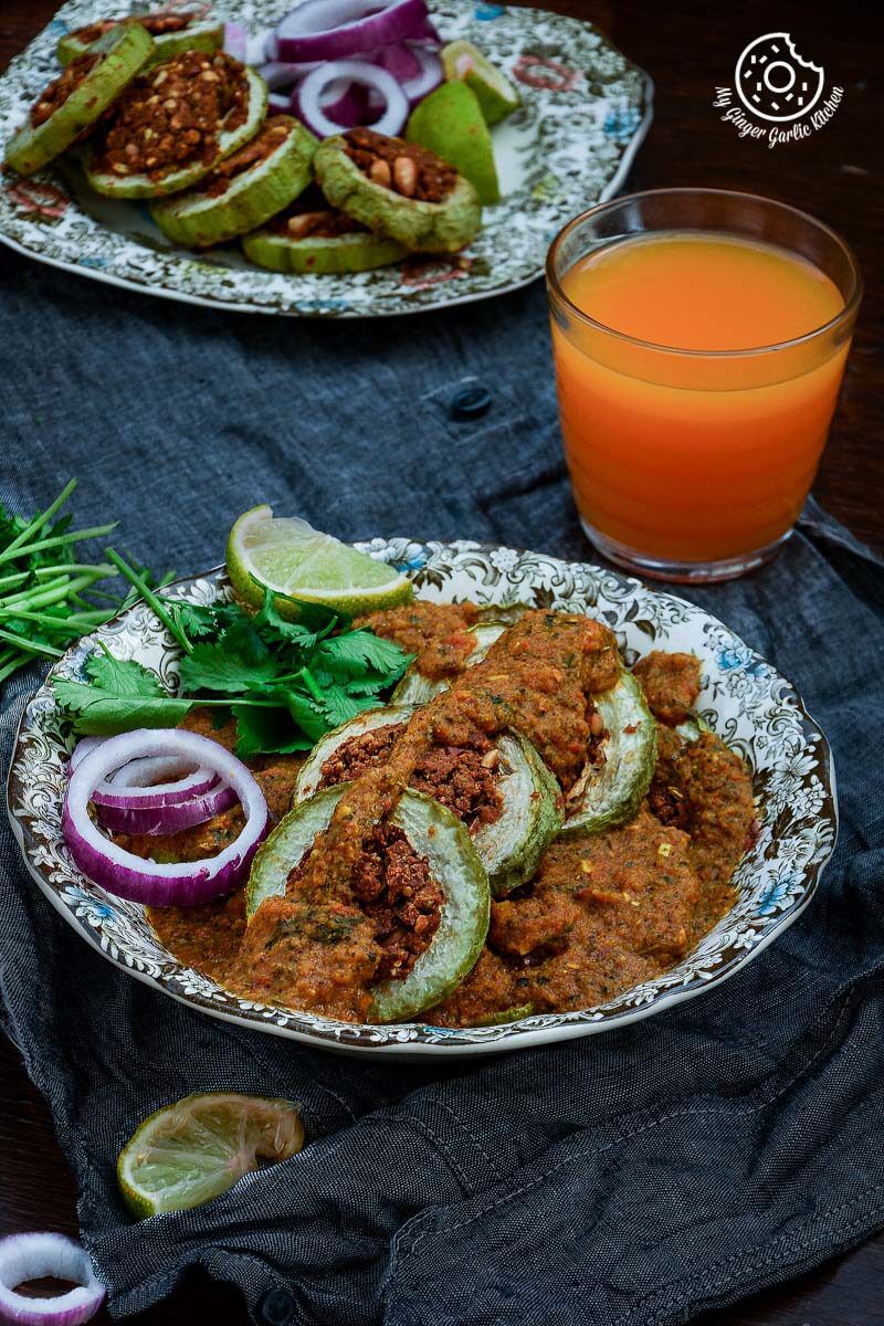 there are two plates of besan lauki curry on a table with a glass of orange juice