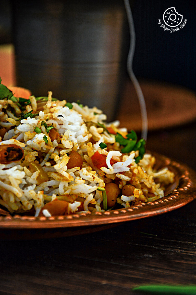 a plate of black eyed bean carrot biryani and vegetables on a table
