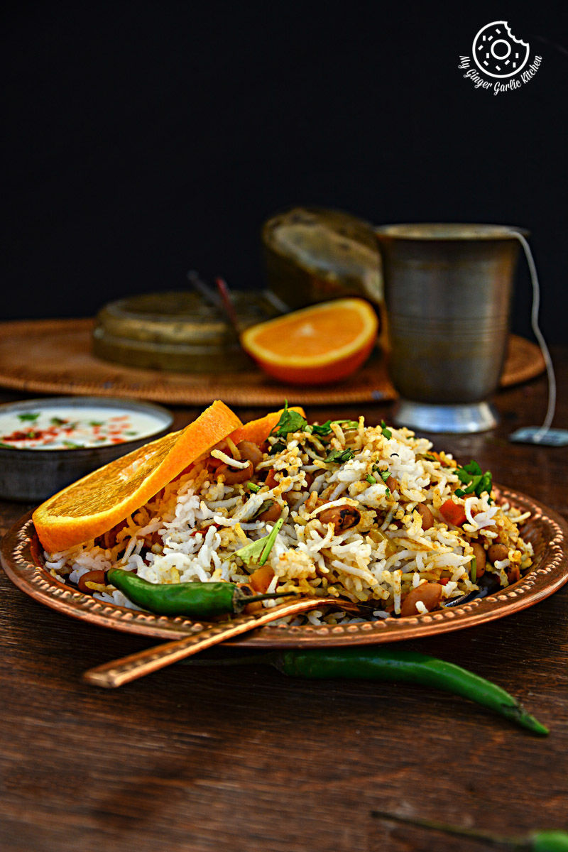 a plate of black eyed bean carrot biryani with rice and vegetables on it
