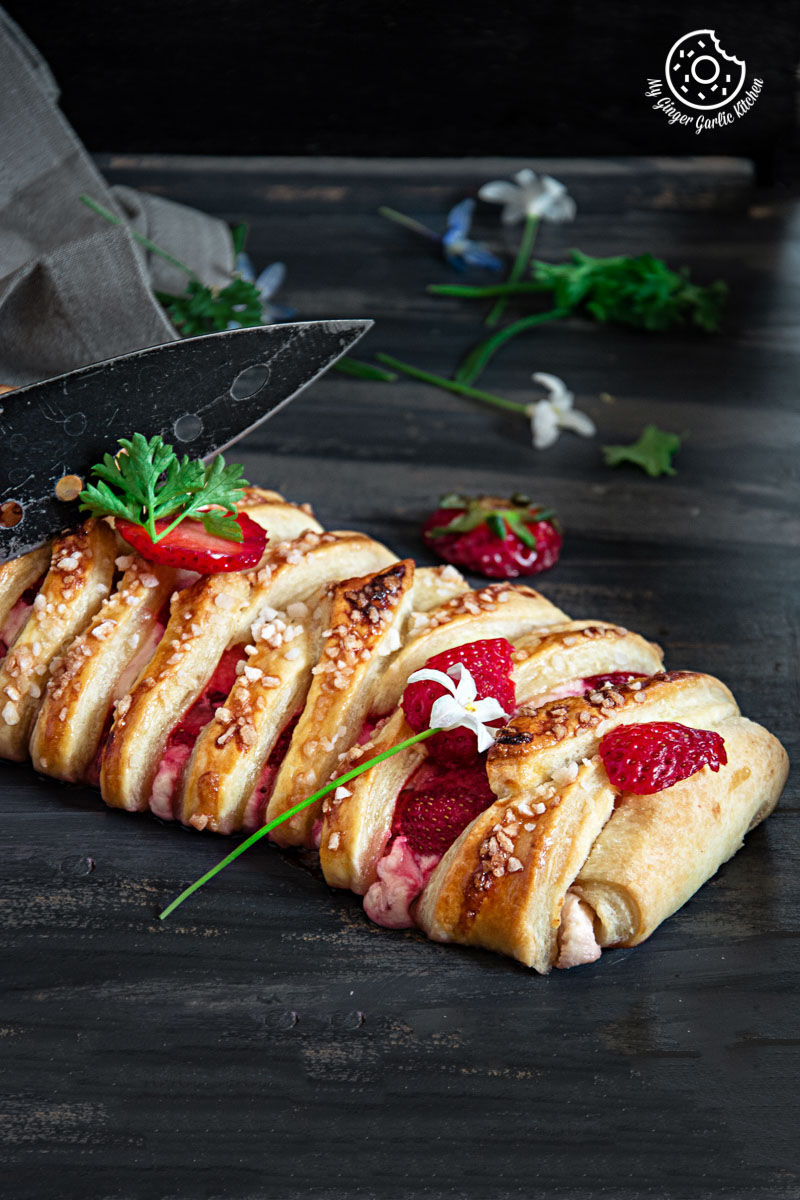 a braided strawberry cream cheese pastry with strawberries on it