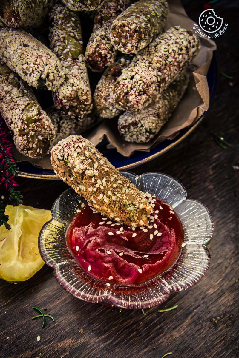 a plate of broccoli beet crispy fingers with a bowl of sauce